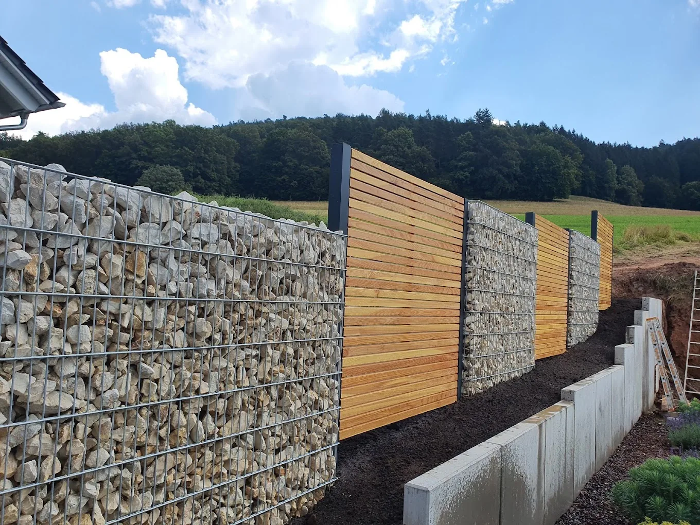 Sichtschutzwand aus Gabionen kombiniert mit Holzelementen